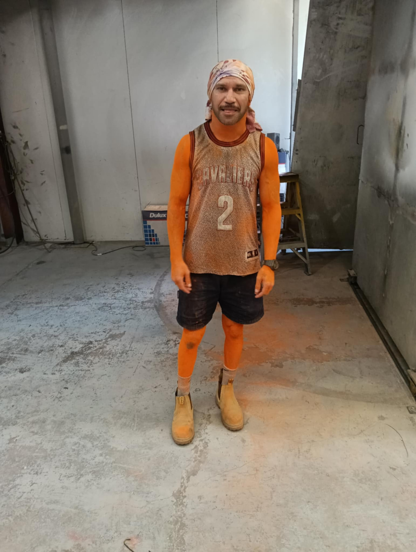 Cody Reid, REIDIFY founder, on the workshop floor covered in orange powder coat